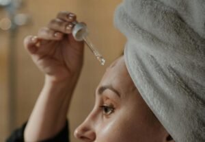 Bild på en kvinna som applicerar niacinamide serum,