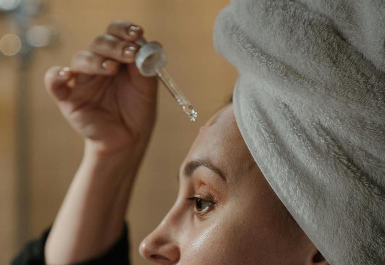 Bild på en kvinna som applicerar niacinamide serum,
